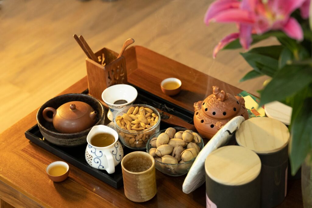 A Chinese tea tray with teapot, cups and nuts on a wooden table